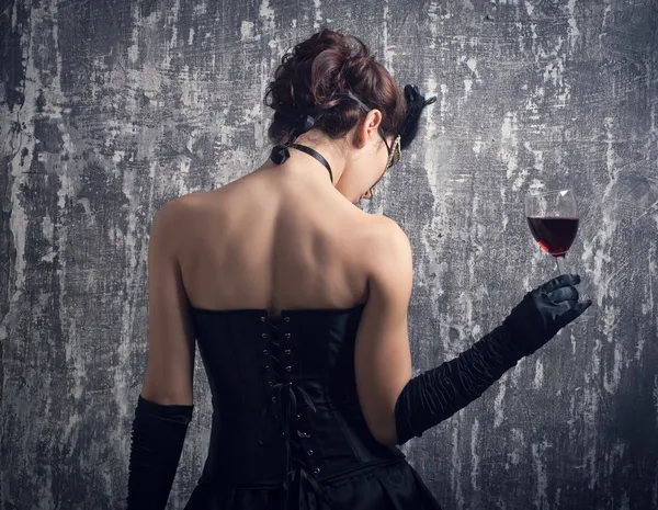 Mulher em máscara com vinho tinto — Fotografia de Stock