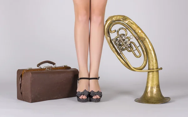 Kadın ayakları, çanta ve trompet — Stok fotoğraf