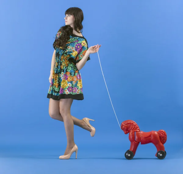 Junge Frau mit Spielzeugpferd — Stockfoto