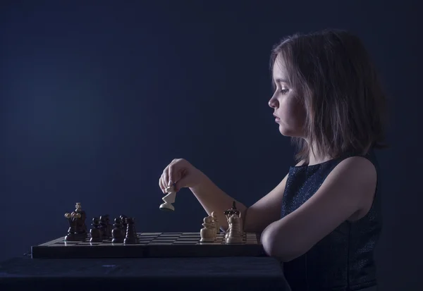 Юная девушка играет в шахматы — стоковое фото