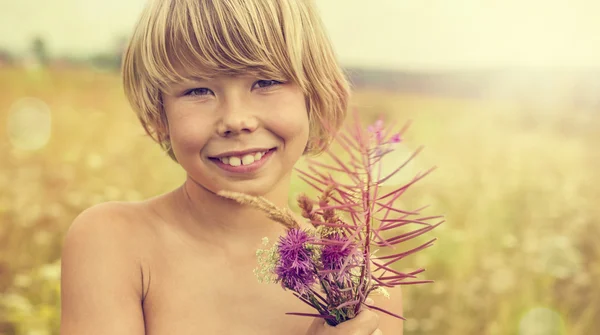 Ragazzo con un mazzo di fiori di campo — Foto Stock