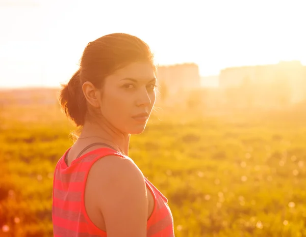 Menina no campo ao pôr-do-sol . — Fotografia de Stock