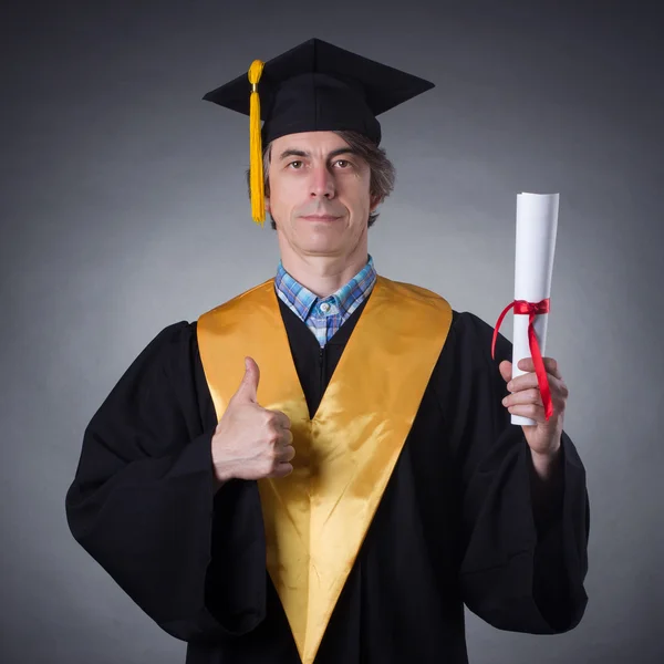 Bărbat într-un capac academic cu diplomă — Fotografie, imagine de stoc