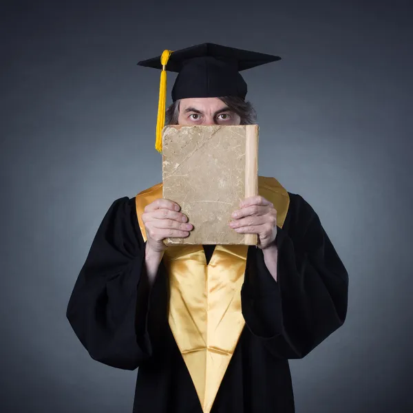 Professor im akademischen Gewand mit altem Buch — Stockfoto