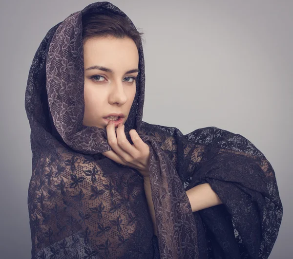 Jonge vrouw in een zwarte kant sjaal. — Stockfoto