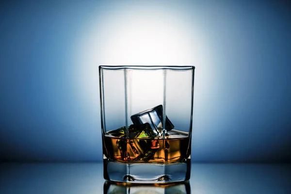Verre Whisky Avec Des Glaçons Sur Table Sur Fond Bleu — Photo