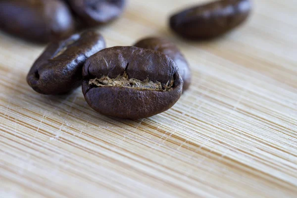 木の表面の近くで焙煎されたコーヒー豆 ロイヤリティフリーのストック写真