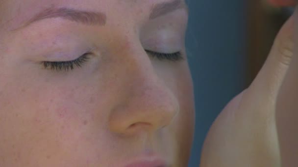 Visagistin trägt Kosmetik auf Frau auf — Stockvideo