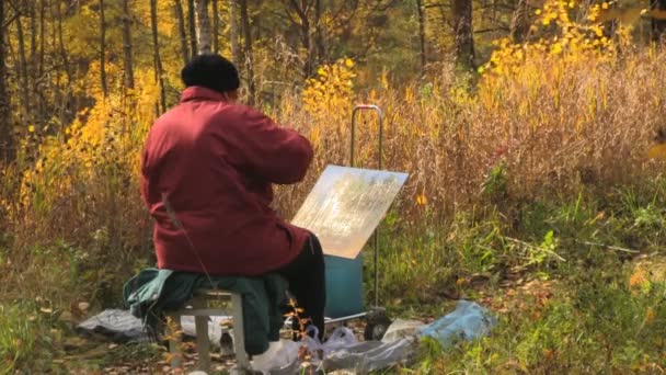 Artysta siedzi w fotelu, przy jego sprzęt artystów, począwszy od rysować — Wideo stockowe