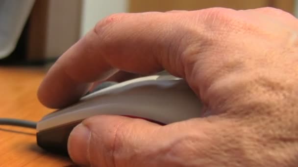 Hand of a man working at computer clicking on mouse on dark desktop — Stock Video