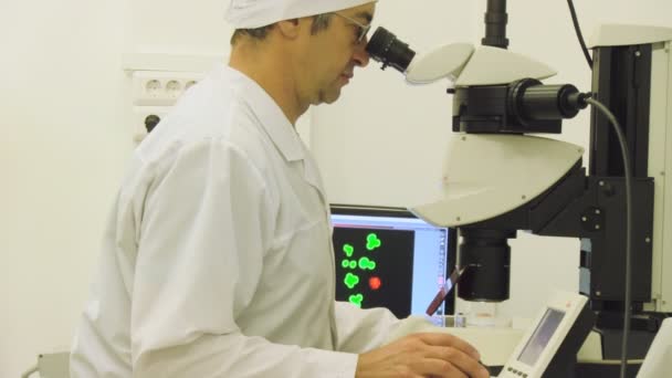 Muž dívá do mikroskopu — Stock video