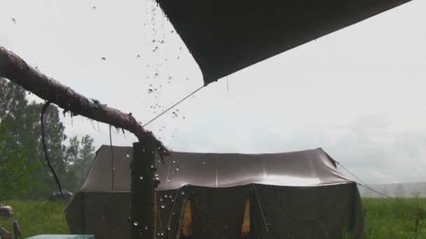 Проливной дождь падает на палатку — стоковое видео