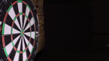 Bir dart tahtasına metal uçlu oklar sıkışmış.