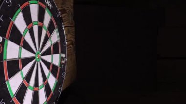 Bir dart tahtasına metal uçlu oklar sıkışmış.