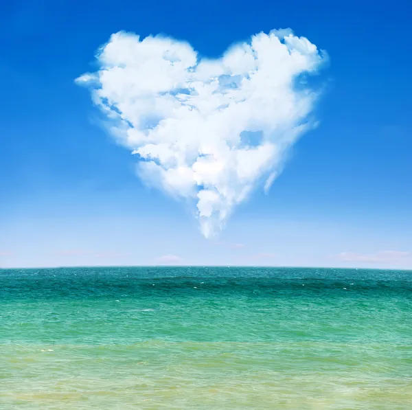 Tenger hullámai és a kék ég felhős szívvel Stock Kép