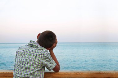 Denizde günbatımında arayan erkek