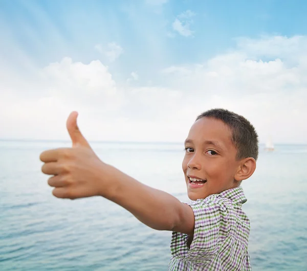 Boy showing thumbs-up against sea — Stock Photo, Image