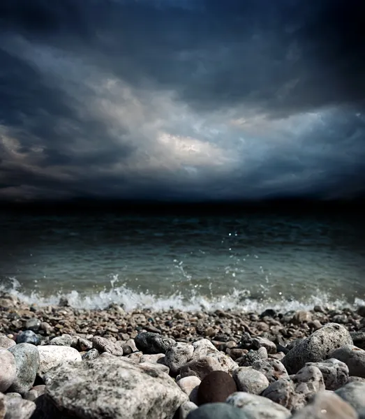 Mer pierres vagues et ciel sombre — Photo