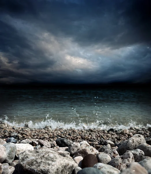 Mar piedras olas y cielo oscuro — Foto de Stock