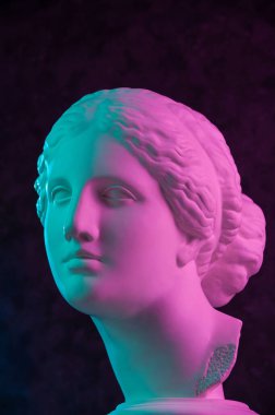 Venus de Milo 'nun antik heykelinin renkli alçıtaşı kopyası koyu dokulu arka plandaki sanatçılar için. Alçı heykel kadın yüzü. Mor renkli sanat posteri ve yeşil parlak renkler. Aşk, güzellik, feminizm