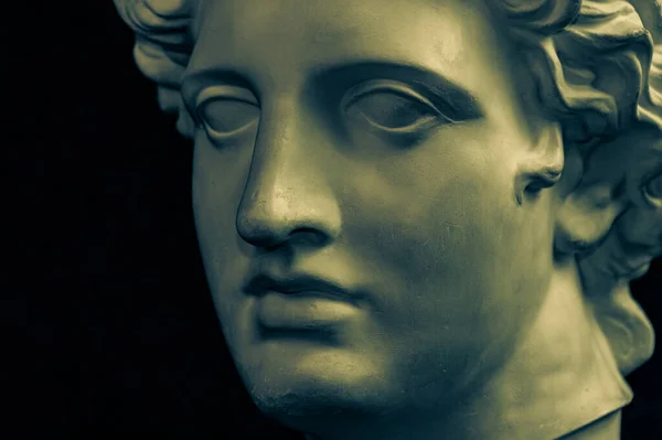 Cópia de gesso cor de bronze da estátua antiga Apollo Deus do Sol e cabeça de poesia para artistas em fundo escuro. Época renascentista. Escultura de gesso de cara de homem. Modelo arte design dj, moda, cartaz — Fotografia de Stock