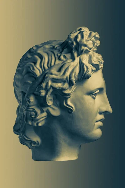 Bronz színű gipsz másolata az ősi szobor Apollo Isten a Nap és a költészet vezetője művészek sárgaréz háttér. Reneszánsz kor. Gipsz szobor az ember arcáról. Sablon art design dj, divat, poszter — Stock Fotó