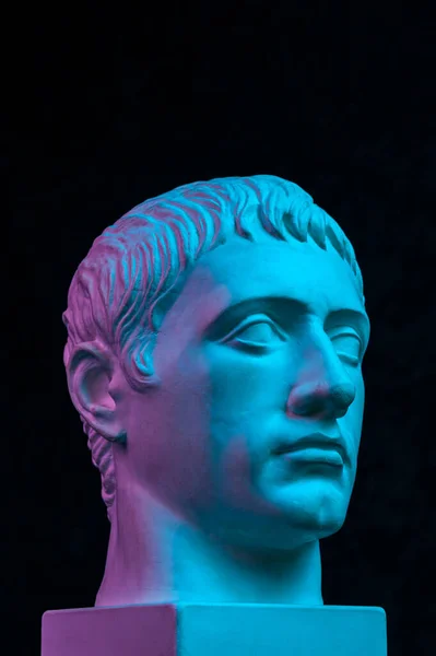 Blue purple gypsum copy of ancient statue of Germanicus Julius Caesar head for artists isolated on black background. Renaissance epoch. Plaster sculpture of man face. Template for art design — Stock Photo, Image