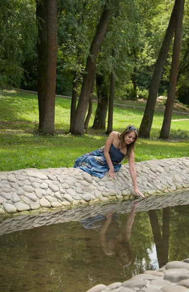 Beautiful woman near stream, reflection — Stock Photo, Image