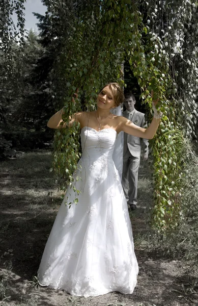 Bruid en bruidegom wandelen in een park — Stockfoto