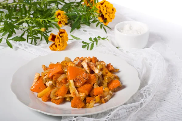Baked pumpkin and marigold on a table — Stock Photo, Image