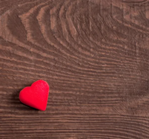 Corazón rojo sobre fondo de madera — Foto de Stock