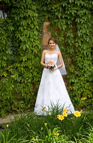 Mooie bruid met bruiloft bloemen — Stockfoto