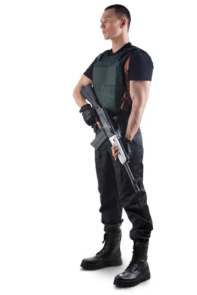 Police officer in body armour is holding a gun. Isolated on whit — Stock Photo, Image