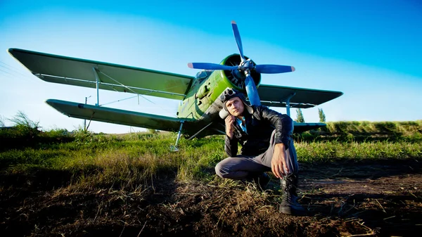 Pilote assis devant un avion vintage — Photo