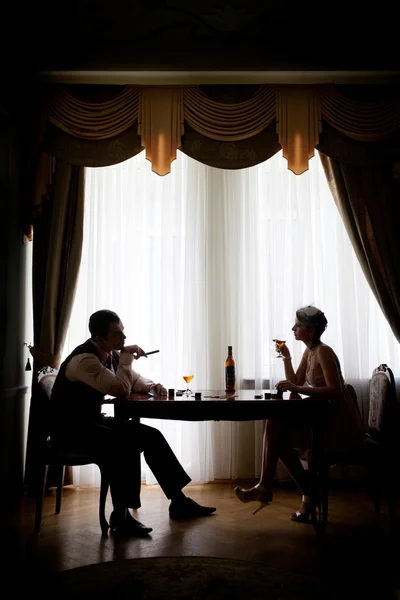 Beautiful couple in the dark corner of a restaurant — Stock Photo, Image