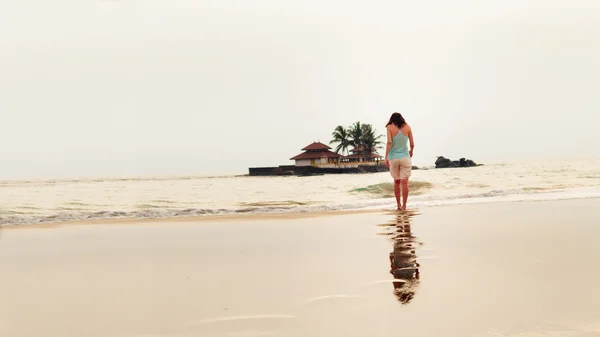 Bella ragazza sta camminando sulla riva del mare — Foto Stock