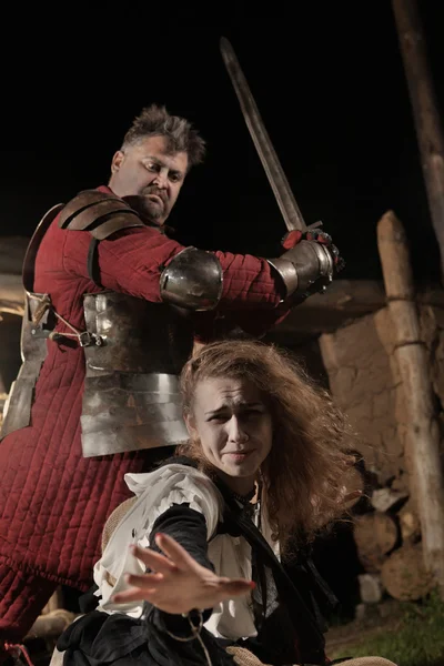 Medieval knight is going to make an execution of a witch — Stock Photo, Image