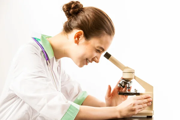 Молодой доктор смотрит в микроскоп — стоковое фото