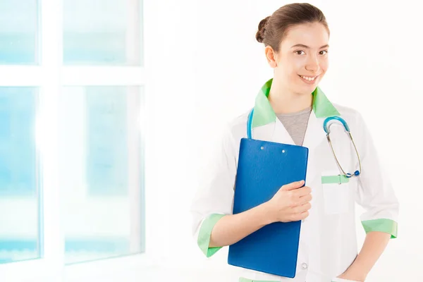 Young doctor in white and green coat with tablet — Stock Photo, Image