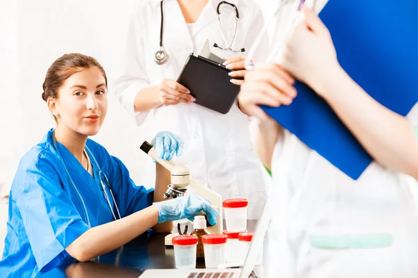 Assistente medico al microscopio Foto Stock