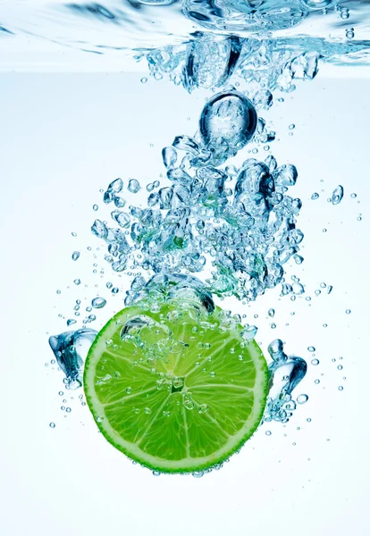 Lime dropped in a water — Stock Photo, Image