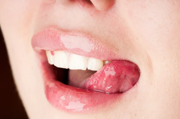 Young female licking her pink lips — Stock Photo, Image