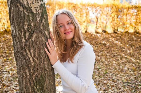 Mulher em pé junto à árvore . — Fotografia de Stock