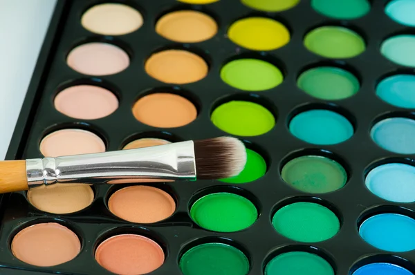 Multicolored eye shadows with cosmetics brush — Stock Photo, Image