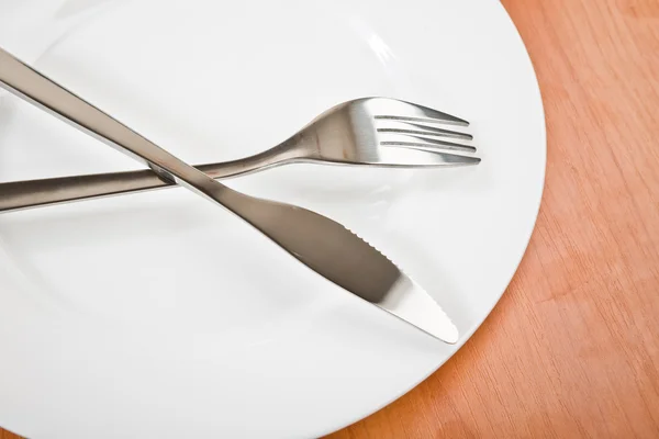 Cuchillo y tenedor en plato blanco — Foto de Stock