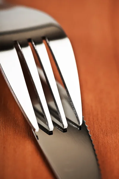 Nůž a vidlička na dřevěném stole — Stock fotografie