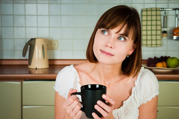 Junge Frau genießt eine Tasse Kaffee in ihrem Haus. — Stockfoto