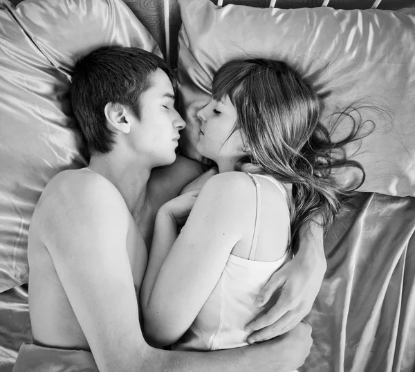 Jovem casal dormindo em uma cama — Fotografia de Stock