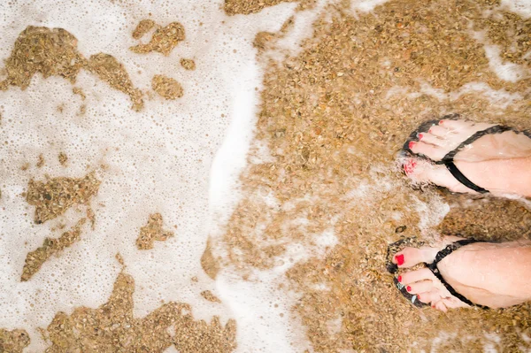 Gambe della ragazza sottile sulla spiaggia di sabbia — Foto Stock