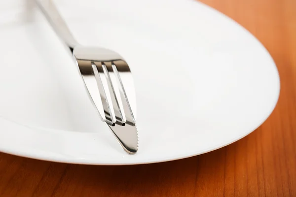 Kniv och gaffel på vit platta — Stockfoto